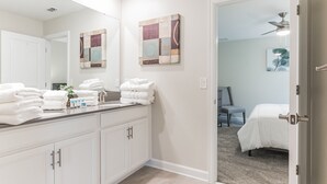 A bathroom with a white vanity, a large mirror, and a ceiling fan. - 1233chd - The Retreat At Championsgate 9 Bedroom Home by RedAwning (Davenport)