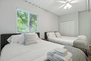 A bedroom with two beds, a ceiling fan, a window with blinds, and a wardrobe. - Modern Comfort Secluded Getaway Fish Creek Pines (Fish Creek)