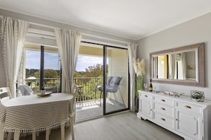 Enjoy a room with a sliding glass door leading to a balcony, featuring a table and chairs for outdoor seating.