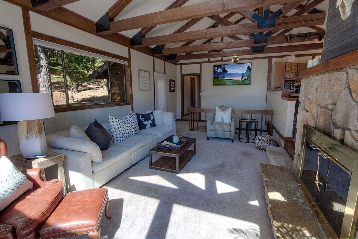 A cozy living room with a white sofa, a coffee table, and a fireplace.