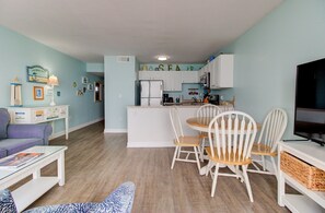Ett kompakt bostadsutrymme med matplats, kök och tv.