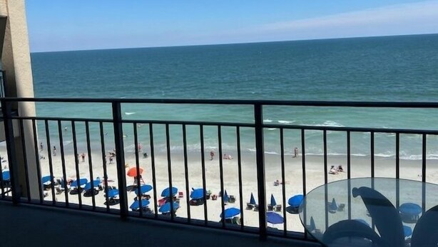 Ein Balkon mit Blick auf Strand und Meer.