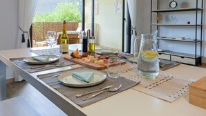 A dining table set with plates, cutlery, a bottle of wine, and a pitcher of water. - Happyfew La terrasse de Flora (Nice)