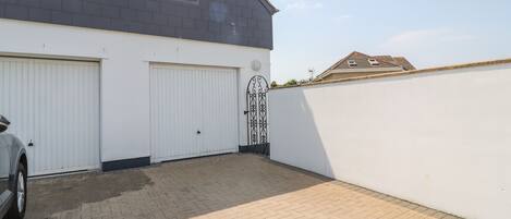 Un bâtiment à deux étages avec un garage et une allée pavée.