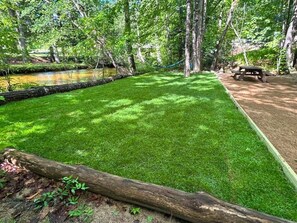 A well-maintained grassy area with a picnic table and a hammock.