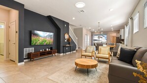 A modern living room with a flat-screen TV, a wooden coffee table, and a sofa.