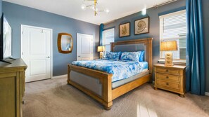 A bedroom with a wooden bed, two bedside tables, a mirror, and a window with curtains. - Last Minute Disney Getaway! Private Pool, Hot Tub & Game Room. Book Now! #79757 (Orlando)