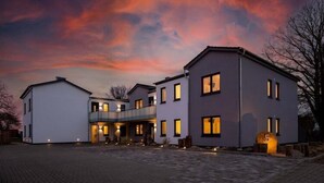 A modern two-story house with a covered patio and a driveway. - Exclusives Appartement auf Fehmarn (Petersdorf)