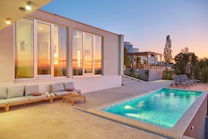 A modern house with a swimming pool, a covered patio, and a view of the sunset. - Villa San Mauro (Buje)