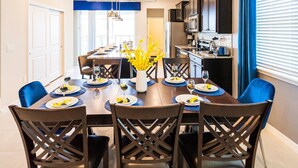 A dining area with a wooden table set for six, surrounded by chairs with a crisscross back design. - Last Minute Disney Getaway! Luxury Villa with Private Pool & Game Room. Book Now! #87165 (Orlando)