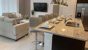 A modern kitchen with a granite countertop, stainless steel appliances, and a built-in island. - Last Minute Disney Getaway! Private Pool & Themed Bedrooms. Book Now! #90485 (Orlando)