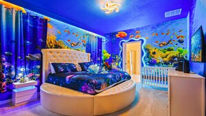 A bedroom with a round bed, aquarium walls, and a ceiling light. - Last Minute Disney! Private Pool, Hot Tub, Game Room & Themed Bedrooms. Book Now! #90909 (Orlando)