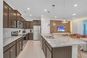 Eine moderne Küche mit Granit Arbeitsplatten, Edelstahlgeräten und dunklen Holzschränken.
