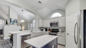 A modern kitchen with white cabinetry, stainless steel appliances, and a large island. - Lovely Lewisville great location minutes to Denton, Flower Mound, & The Colony! (Lewisville)