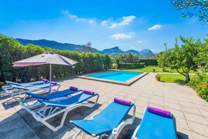 Relax by the serene pool surrounded by lush greenery and majestic mountains.