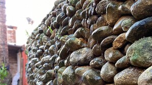 Un muro de piedra con un estrecho sendero a su lado.