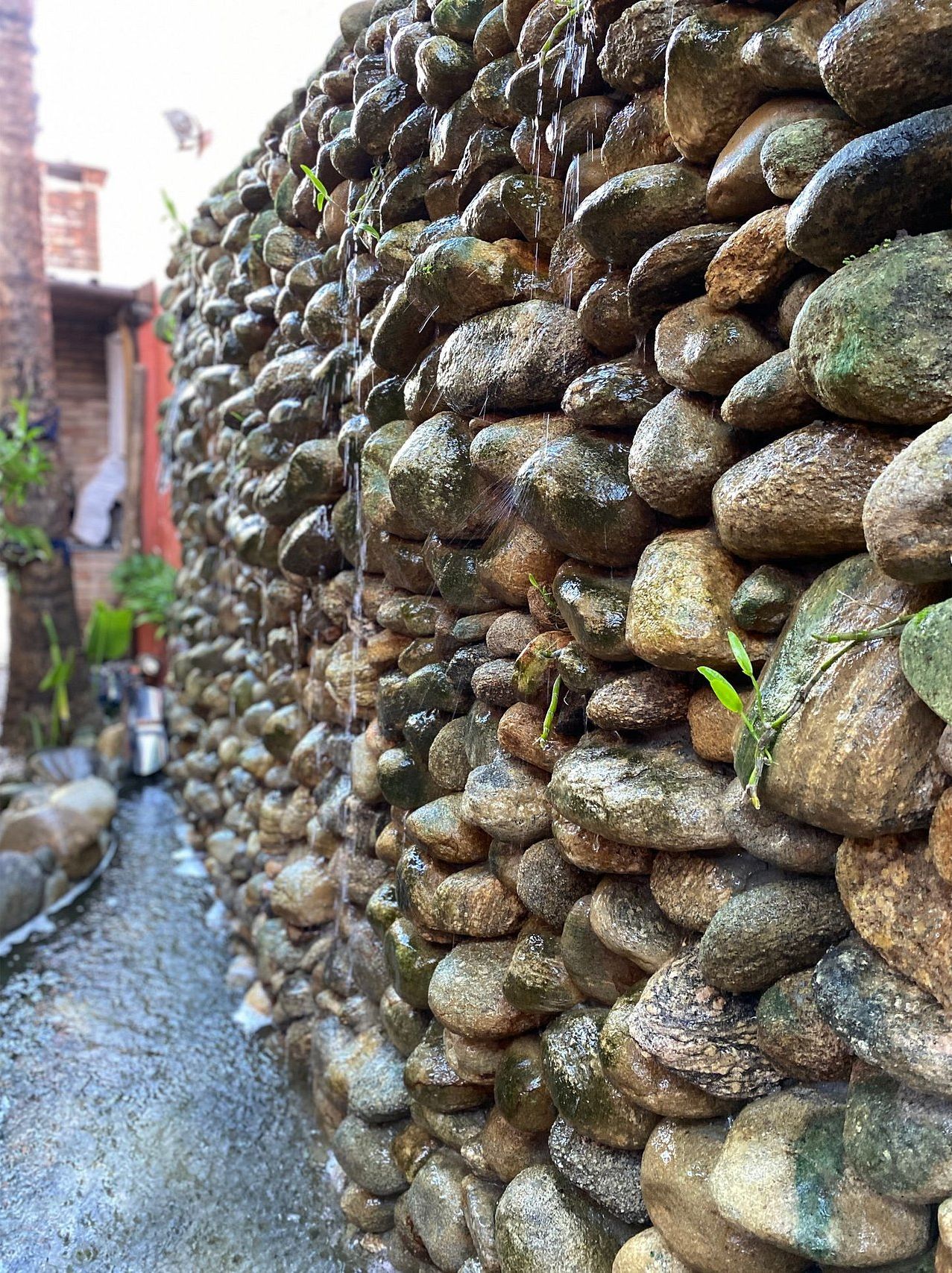A stone wall with a narrow path beside it.