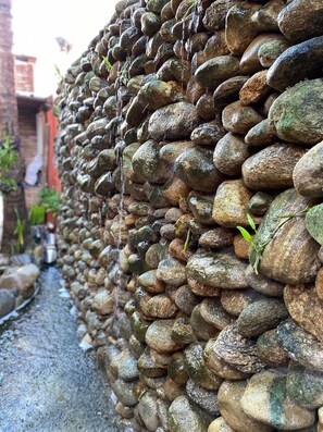 A stone wall with a narrow path beside it. - Lalabella Itagua (Ubatuba)