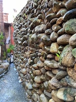 Un muro de piedra con un estrecho sendero a su lado.