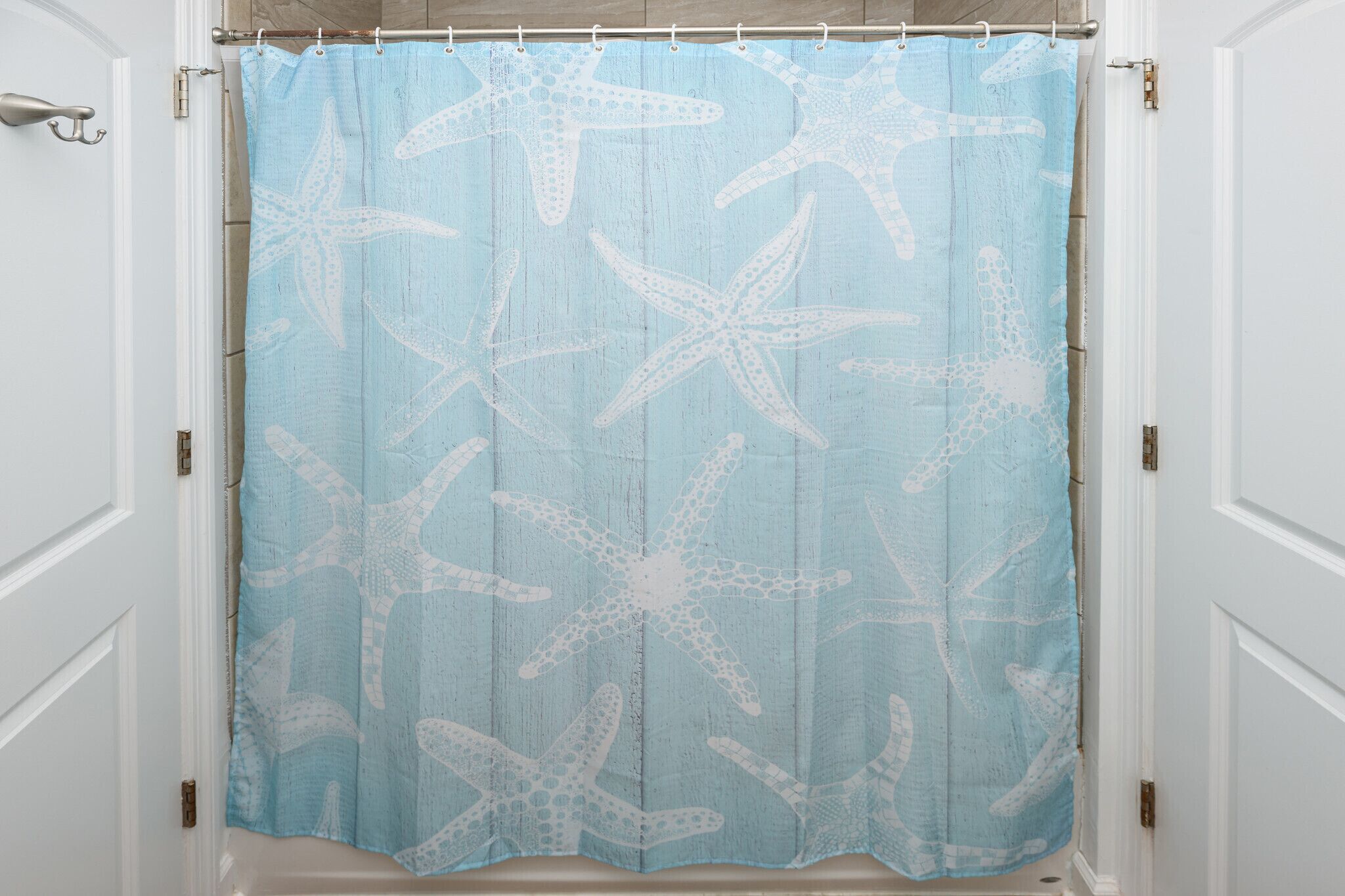A bathroom with a shower curtain featuring a starfish pattern.