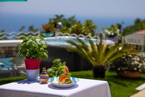 Une table avec une salade, une plante en pot et un vase décoratif.
