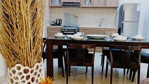 A modern kitchen with wooden cabinets, a stainless steel refrigerator, and a dining table set for four. - Lacasa chalet panoramic view to dead sea (Sweimeh)