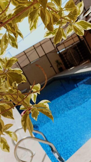 A swimming pool with clear blue water, surrounded by a covered area with a tiled floor. - Lacasa chalet panoramic view to dead sea (Sweimeh)
