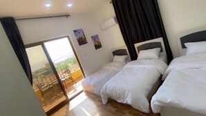 A hotel room with two beds, a balcony with a railing, and a sliding glass door. - Lacasa chalet panoramic view to dead sea (Sweimeh)