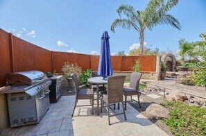 Enjoy al fresco dining and relaxation in this patio area, complete with a barbecue grill and comfortable seating.