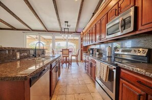 Enjoy cooking and socializing in this well-equipped kitchen with a central island and wooden cabinetry.