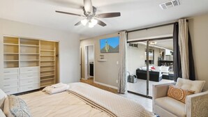 Quarto com cama, cadeira, guarda-roupa e porta de correr para um banheiro.