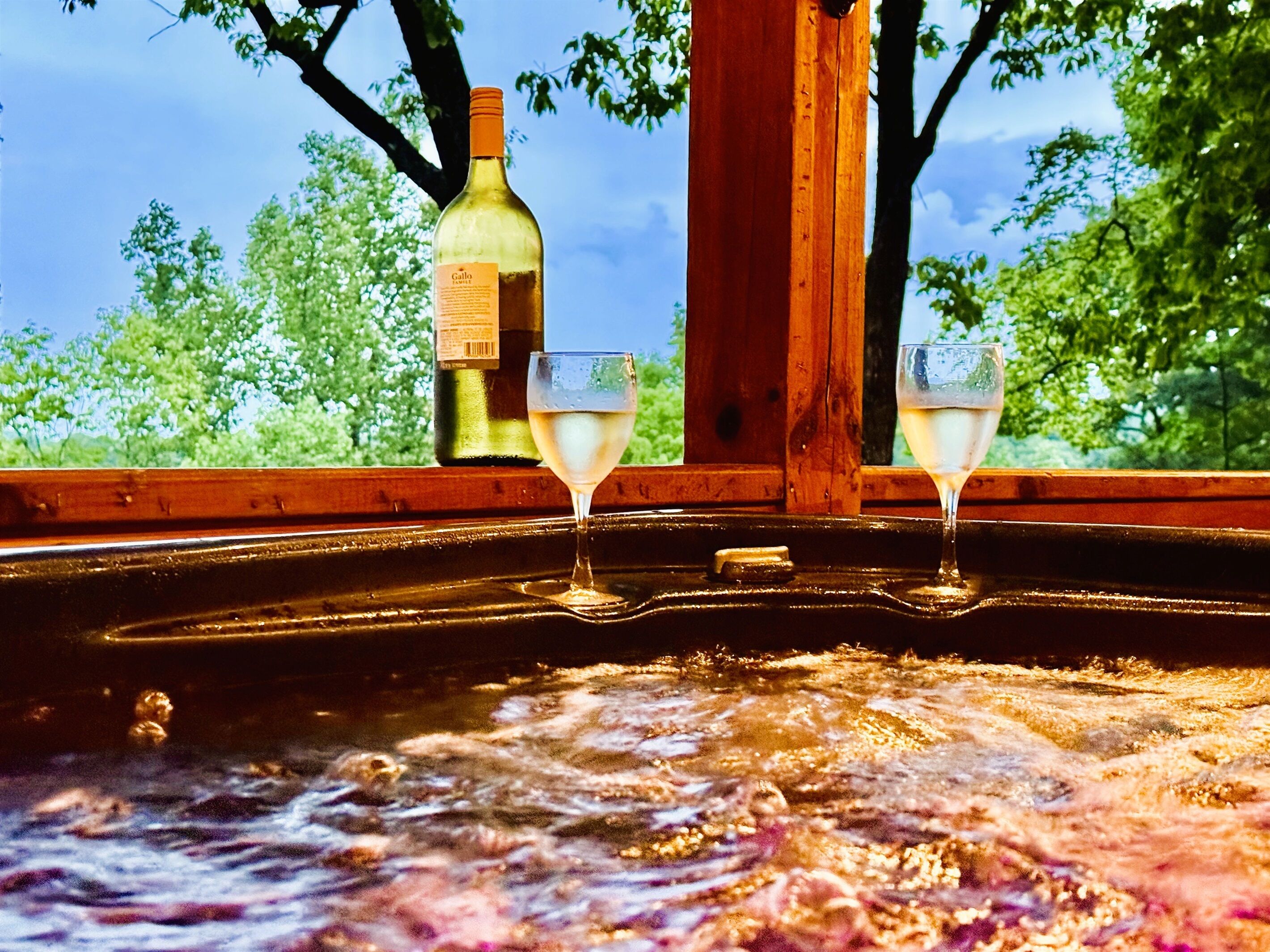 Ein Whirlpool mit zwei Gläsern Weißwein und einer Weinflasche.