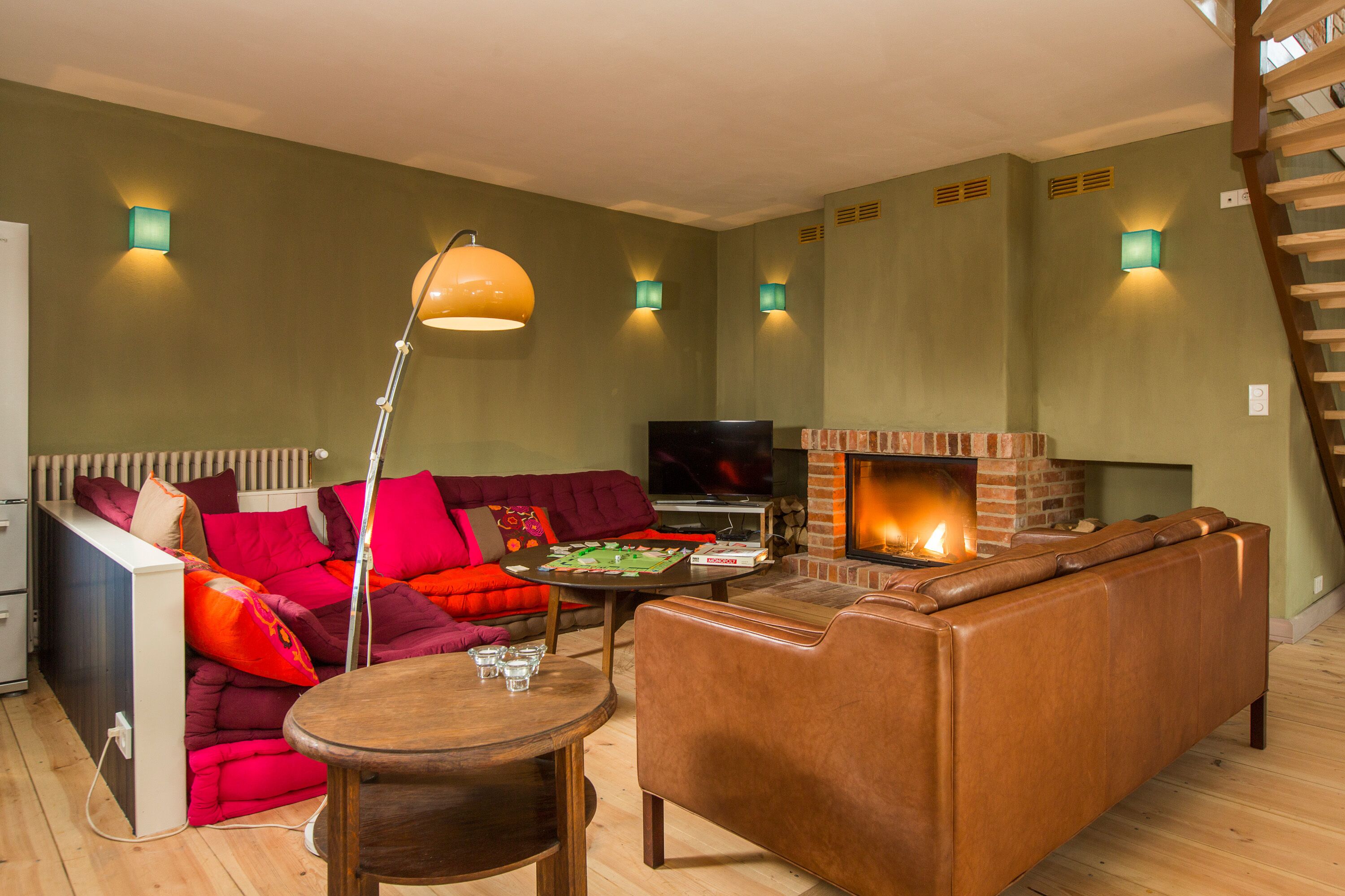 Ein gemütliches Wohnzimmer mit Kamin, einer Couch, einem Couchtisch und einem Fernseher.