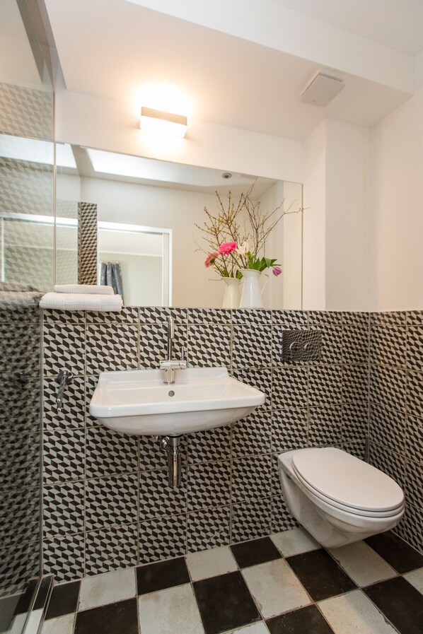 A bathroom with a checkered floor, a sink, and a toilet. - 4 Bedroom Apartment in Walow (Walow)