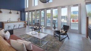 A spacious living room with a modern kitchen, large windows, and a view of the city. - 1Bed/1Bath - Gorgeous Downtown Austin Resort!! (Austin)