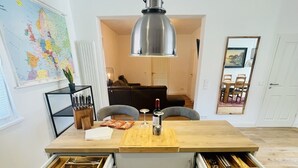 Una cocina moderna con una isla de madera, cajones integrados y una lámpara colgante.