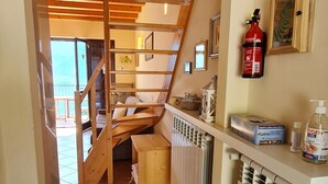 Una cocina con escalera de madera, extintor y radiador.