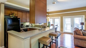 A kitchen with a central island, wooden cabinets, and a black refrigerator.