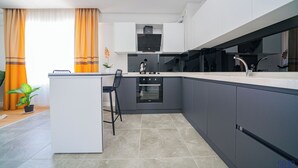 A modern kitchen with grey cabinets, a built-in oven, and a white countertop.