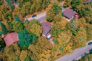A residential area with multiple houses surrounded by dense trees.