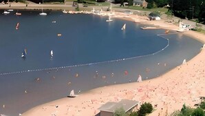 Una extensa masa de agua con varios barcos y una zona de playa arenosa.