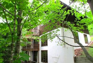 Ein zweistöckiges Gebäude mit Balkon und weißer Fassade.