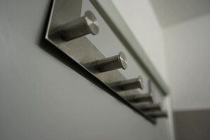 Superficie metálica reflectante con objetos cilíndricos adheridos, probablemente un elemento decorativo moderno en una habitación.