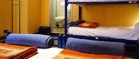 A bunk bed room with a metal rack, a toilet, and towels with "OSTELLMILANO" text.