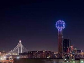 Spanning the city, a cable-stayed bridge connects to a striking tower with a dynamic lighting display.