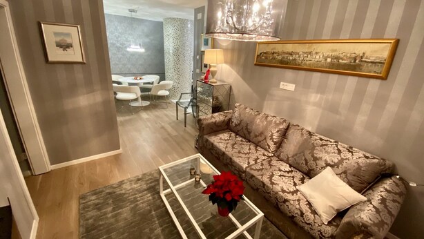 A modern living room with a patterned sofa, a glass coffee table, and a dining area in the background. - Top Location, Stylish Apartment, City Center, Nearby Parking, Bus/train Station (Ljubljana)