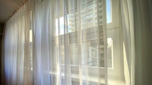 A room with sheer white curtains partially drawn, allowing natural light to enter. - Top Location, Stylish Apartment, City Center, Nearby Parking, Bus/train Station (Ljubljana)