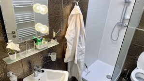 A modern bathroom with a white sink, a glass shower enclosure, a toilet, and a towel hanging on a rack. - Top Location, Stylish Apartment, City Center, Nearby Parking, Bus/train Station (Ljubljana)