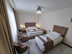 A hotel room with two beds, a chair, a small table, and a ceiling light fixture. - ELİTE PARK HOTEL & SUİTES (Istanbul)