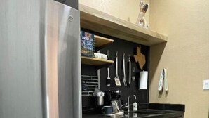 A modern kitchen with stainless steel appliances, black countertops, and wooden cabinets. - WunderDog BunkHouse: Ready for FISHing men and women. Privacy for 4! (Rockport)